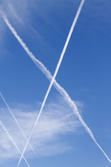 X traces - Clouds in the blue sky and the traces of the planes.