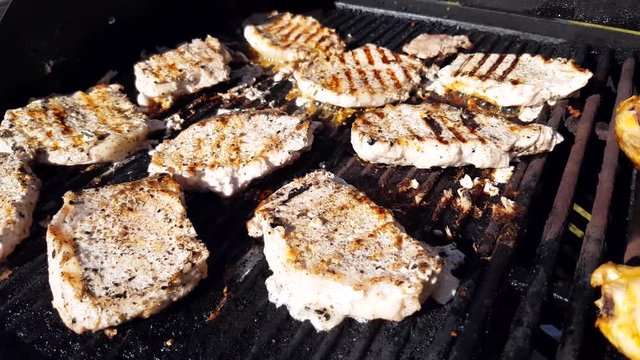 Grilling pork loin steaks and chicken, on a gas barbeque