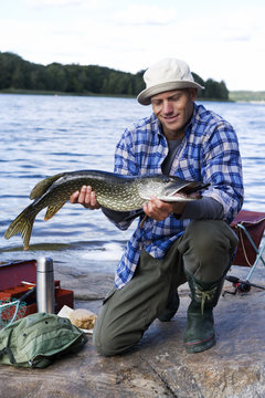 A man holding a pike, Sweden.