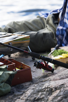 A man barbecuing fish by the water, Sweden.