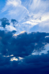 Naklejka na ściany i meble Clouds developing into a storm on a blue sky background