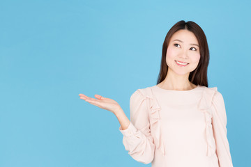 portrait of asian woman showing isolated on blue background