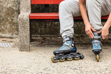 Woman putting on roller skates outdoor.