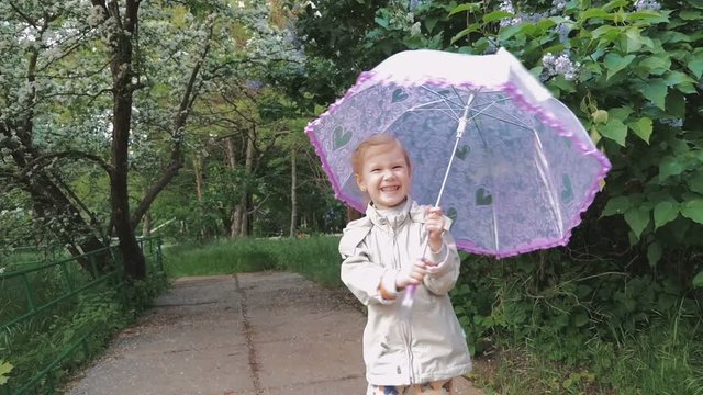 little girl  in park with umbrella after rain