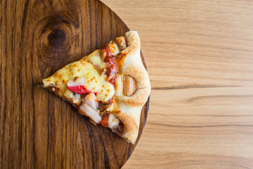 Pizza on wooden plate on top table background