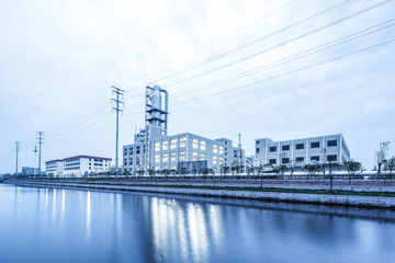 modern factory near river in cloud sky