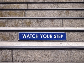 Watch your step sign on a staircase