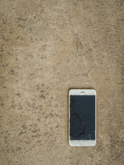 Top View of Crack Screen Smart Phone on the Cement Floor with Copy Space