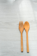 Background of a wooden spoon and fork on gray wooden floors