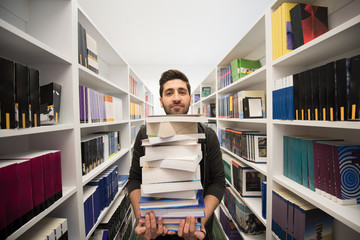 Student holding lot of books in school library