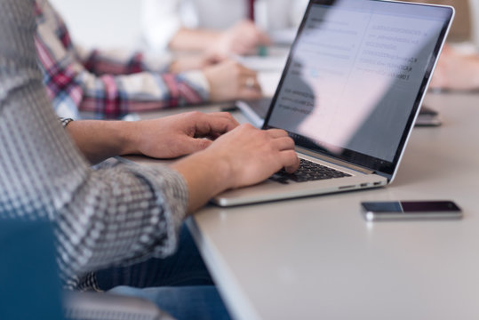 Close Up Of Business Man Hands Typing On Laptop With Team On Mee