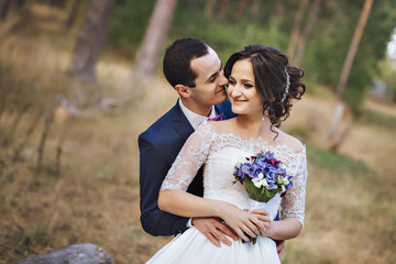 Couple in pine forest, looking at each other. Love and happy husband  wife.