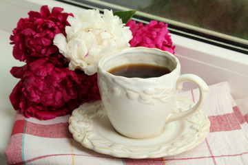 a bouquet of red and white peony on a wooden background near a Cup of strong coffee