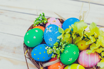 Easter eggs painted in pastel colors on white wooden background.