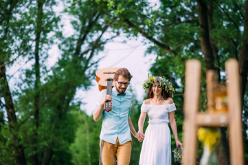 Fototapeta premium couple walking happily among the trees, looking down