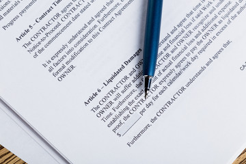Obraz premium Pen and contract papers on wooden desk