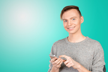 Young man typing text message on his cellphone