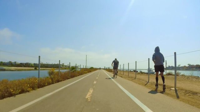 POV from person riding a bicycle on bike path next to ocean