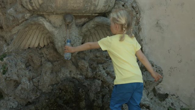 Piccola bambina bionda beve acqua a Roma, Italia, Europa