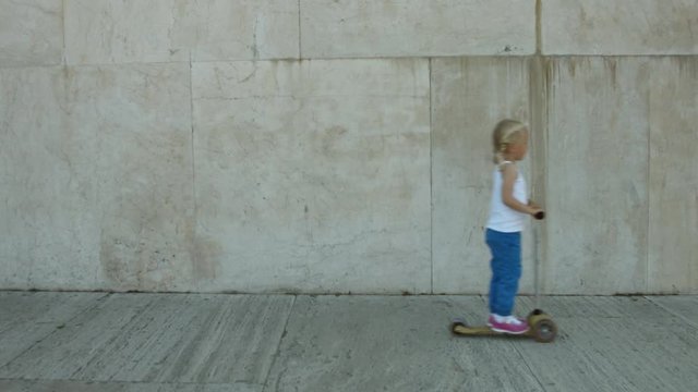 Piccola bambina bionda in monopattino  a Roma, Italia, Europa