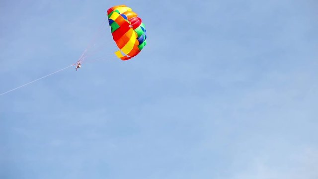 Parasailing under a cheerful rainbow colored parachute