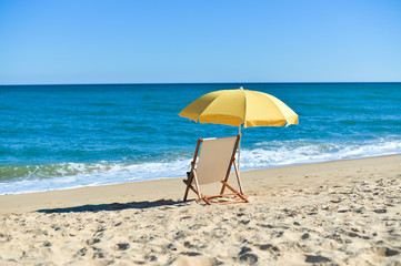 Back View Of Deckchair, Sun Lounger Under Umbrella On Sand Beach. 