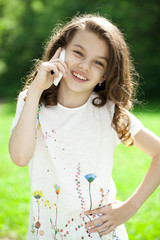 Portrait of a beautiful young little girl calling by phone