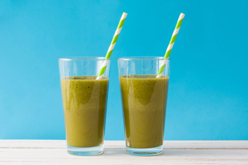 Healthy green detox with spinach on blue background