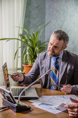 businessman sitting in conference hall and working with documents and business graphics