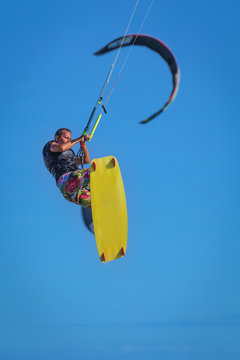 Athletic man riding on kite surf board at sea waves