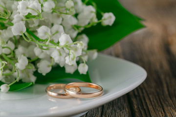 Obraz na płótnie Canvas Wedding rings with flower background