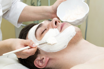 Obraz na płótnie Canvas man in the mask cosmetic procedure in spa salon