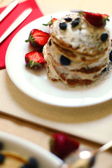 studio photo of breakfast table, sweet pancakes with summer berries  