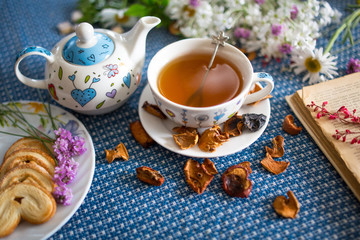 Obraz na płótnie Canvas cup of tea with book and flower
