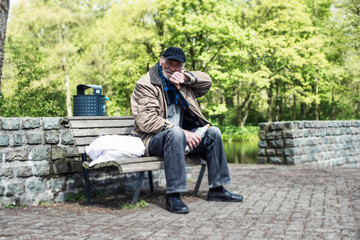Homeless man wipes his mouth with his sleeve.