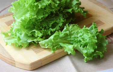 A bunch of lettuce lying on the board..