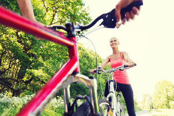 Fototapeta na wymiar close up of happy couple riding bicycle outdoors