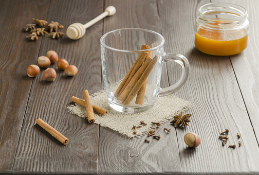 Glass cup of  tea on a linen napkin with cinnamon sticks, honey, nuts and  spice. Blur effect. Background. Copyspace