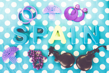Spain made of plastic letters, castanet and costume jewelry