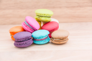 Fototapeta na wymiar Sweet and colourful french macaroons or macaron on wood background, Dessert. 