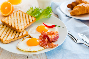 Breakfast withn fried eggs and croissant