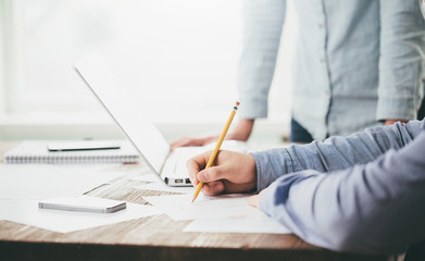 Website developers working using  laptop at the office on wooden