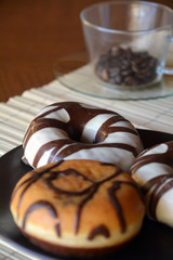Traditional  donuts  with brown chocolate on the plate on the table