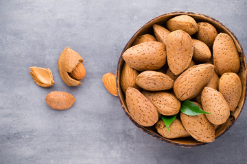 Group of almond nuts with leaves.Wooden background.