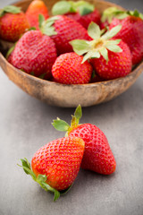 Strawberry in a bowl on the gray background.
