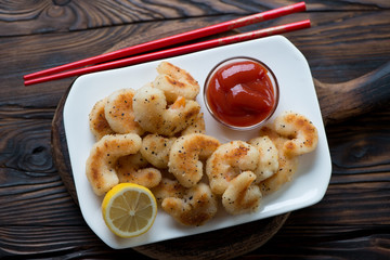 Above view of fried panko breaded shrimps, rustic wooden setting