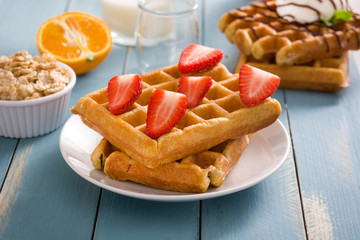 Waffles with strawberries on blue wood
