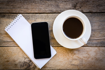 cup of coffee and smartphone with paper note on wood table backg