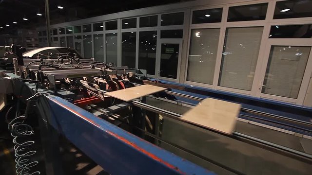 Ceramic tiles manufacturing. Sorting and packaging of ceramic tiles on a fully automated packaging line. Ceramic tiles moving on the production line.