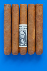 Detail of luxury Cuban cigars with US dollar